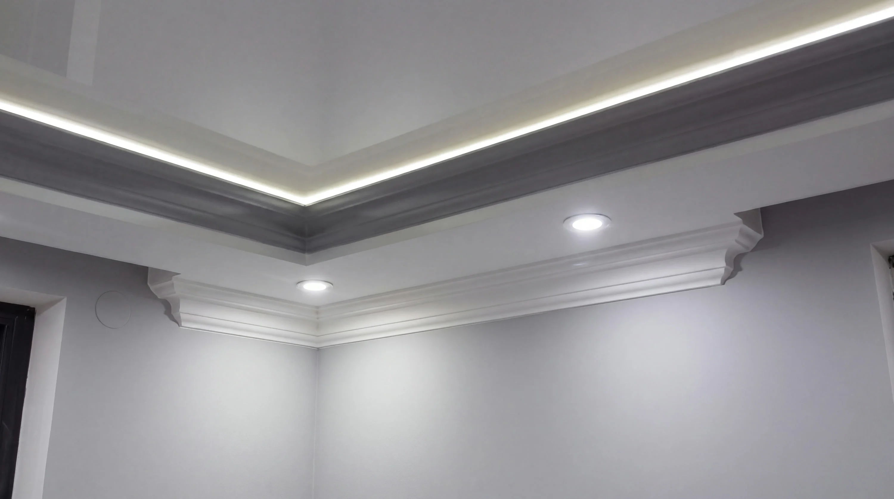 Detail einer Deckenecke mit Lichtfuge und weißem Stuckprofil