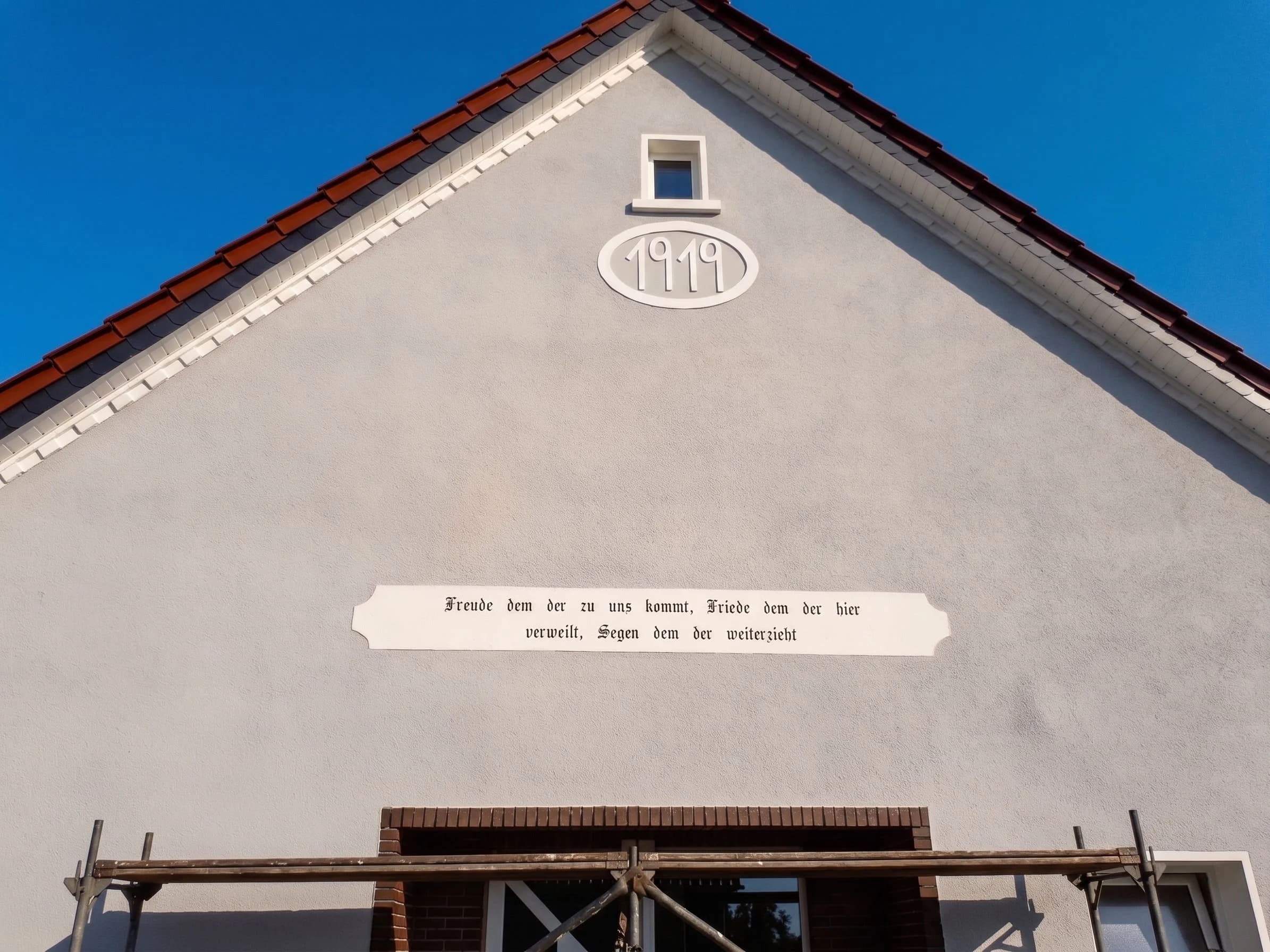 Sanierter Hausgiebel von 1919 mit restaurierter Inschrift