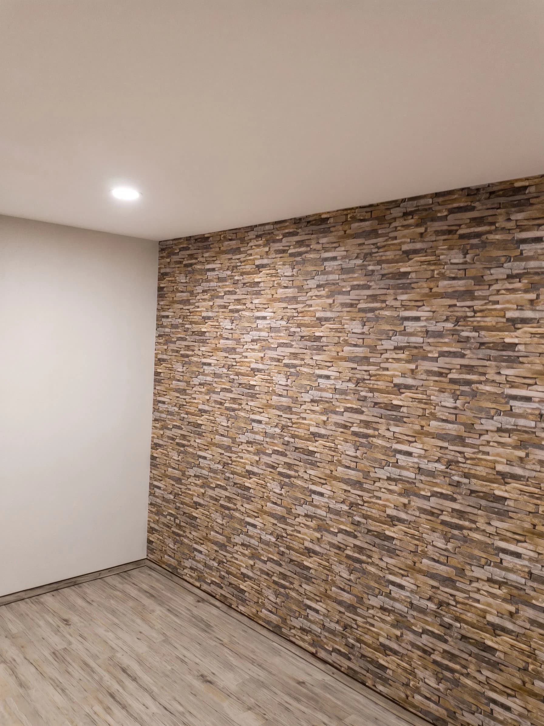 Akzentwand aus Steinriemchen neben heller Wandfläche