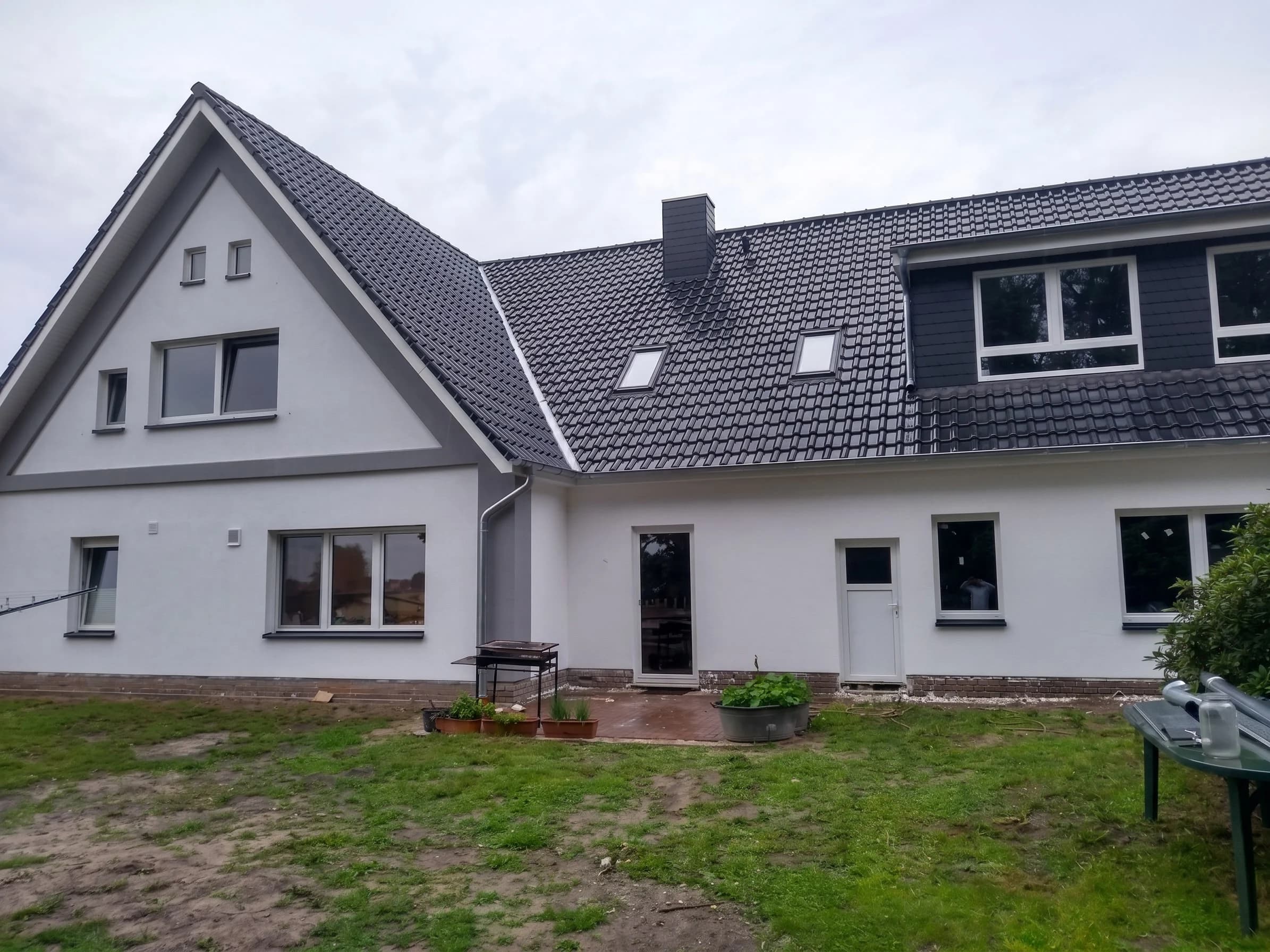 Saniertes Wohnhaus mit hellgrauer Fassade und dunklem Dach